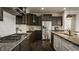 Modern kitchen with dark cabinets, stainless steel appliances, granite countertops, and a gas stovetop at 4428 Voyageur Way, Carmel, IN 46074