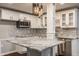 Kitchen features white cabinets, granite counters and stainless appliances, pendant lighting and wine rack detail at 4428 Voyageur Way, Carmel, IN 46074