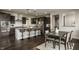 A modern kitchen with dark cabinets, stainless steel appliances, granite countertops, an island, and dining table at 4428 Voyageur Way, Carmel, IN 46074