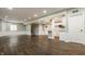 Spacious open concept living area with stairs, partial kitchen island, wood floors, and crisp white trim at 4428 Voyageur Way, Carmel, IN 46074