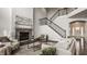 Comfortable living room featuring a stone fireplace and staircase to the second floor at 4428 Voyageur Way, Carmel, IN 46074