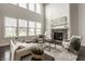 Open living room with soaring ceilings, large windows, and a cozy fireplace at 4428 Voyageur Way, Carmel, IN 46074
