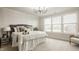 Main bedroom featuring a luxurious bed, chair, large windows, modern light fixture, and neutral decor at 4428 Voyageur Way, Carmel, IN 46074