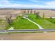 An aerial view of a home on a large lot featuring a long driveway and surrounding farmland at 52 E 286Th St, Atlanta, IN 46031