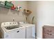 Functional laundry room featuring a washer, dryer, storage shelves, and a wood cabinet at 52 E 286Th St, Atlanta, IN 46031