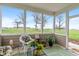 Comfortable screened porch with outdoor furniture, plants, and a calming view of the green surroundings at 52 E 286Th St, Atlanta, IN 46031