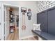 Mudroom with a built-in bench, hooks, and dog-themed wallpaper, next to a well-organized storage room at 5218 Pinehurst Ct, Whitestown, IN 46075