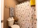 Cozy bathroom featuring a patterned shower curtain and decorative towels and a small shelf for decor at 5251 Ladywood Bluff Pl, Indianapolis, IN 46226