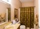 This bathroom features a marble countertop sink with bronze fixtures and a shower with decorative curtain at 5251 Ladywood Bluff Pl, Indianapolis, IN 46226