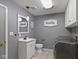 Laundry room featuring gray paint, tile floors, vanity, mirror, laundry sign, and modern washer and dryer at 5307 S State Road 135, Morgantown, IN 46160