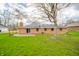 Back exterior of brick home with walk-out deck, and green lawn at 5576 N Heritage Ln, Alexandria, IN 46001
