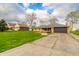 This single-story brick home includes a two-car garage and cracked driveway at 5576 N Heritage Ln, Alexandria, IN 46001