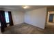 A simple bedroom featuring neutral walls, carpet flooring, and a window with dark curtains at 5609 Sweet River Dr, Indianapolis, IN 46221