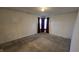An empty bedroom featuring neutral walls, carpet flooring, and a window with dark curtains at 5609 Sweet River Dr, Indianapolis, IN 46221