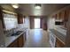 An efficient kitchen featuring wood cabinets, white appliances, and a sliding door to the backyard at 5609 Sweet River Dr, Indianapolis, IN 46221