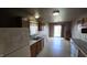 Compact kitchen featuring wood cabinets, white appliances, and a view into a bright dining area at 5609 Sweet River Dr, Indianapolis, IN 46221