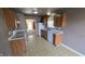 Compact kitchen with wood cabinets, white appliances, and a view into another room at 5609 Sweet River Dr, Indianapolis, IN 46221