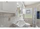 Bathroom with a glass block window, tiled walls, and white vanity at 5747 Allisonville Rd, Indianapolis, IN 46220