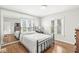 Sunlit bedroom with hardwood floors, a large mirror and two bright windows at 5747 Allisonville Rd, Indianapolis, IN 46220