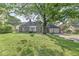Charming brick home with mature tree, landscaped lawn, and an attached two-car garage at 5747 Allisonville Rd, Indianapolis, IN 46220
