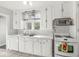 Traditional kitchen featuring white cabinets, tile countertops, and modern appliances at 5747 Allisonville Rd, Indianapolis, IN 46220