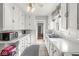 Galley kitchen featuring white cabinets, tiled floors, and stainless steel appliances at 5747 Allisonville Rd, Indianapolis, IN 46220