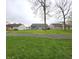 Spacious backyard showing a large green lawn, trampoline, and a wooden deck ideal for relaxation and outdoor entertaining at 5848 Jackie Ln, Indianapolis, IN 46221
