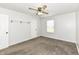 This is a neutral bedroom with a ceiling fan, carpet flooring, and a window at 5855 La Fleur Ct, Indianapolis, IN 46237