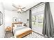 Staged bedroom features a ceiling fan, large window with sheer curtains, and stylish decor at 5855 La Fleur Ct, Indianapolis, IN 46237