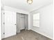 This bedroom features neutral carpet, an open closet with gray curtains, and natural light from the window at 5855 La Fleur Ct, Indianapolis, IN 46237