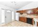Cozy kitchen featuring oak cabinets, tile backsplash, white appliances, and a tile floor at 5855 La Fleur Ct, Indianapolis, IN 46237