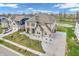 Aerial view showcasing a brick home, extended driveway, landscaping and the surrounding community pond at 6044 Shallow Crk Ln, Indianapolis, IN 46237