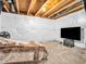 Finished section of the basement displaying a bed, fan, and TV, showcasing a versatile and comfortable space at 6044 Shallow Crk Ln, Indianapolis, IN 46237