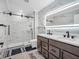 Bright bathroom showcasing a glass shower, double vanity with sleek fixtures, and stylish marble-look tiles at 6044 Shallow Crk Ln, Indianapolis, IN 46237
