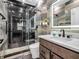 Modern bathroom featuring a glass enclosed shower, a sink vanity with mirror, and sleek gray tiling at 6044 Shallow Crk Ln, Indianapolis, IN 46237