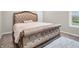 Elegant bedroom featuring a tufted upholstered bed frame, soft bedding, and a plush rug at 6044 Shallow Crk Ln, Indianapolis, IN 46237