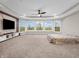 Open bedroom with tray ceiling, large bay window, and statement wall and media center at 6044 Shallow Crk Ln, Indianapolis, IN 46237
