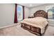 Comfortable bedroom with a dark wood sleigh bed, soft bedding, and natural light from large windows at 6044 Shallow Crk Ln, Indianapolis, IN 46237