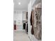 Bright walk-in closet featuring custom shelving and clothing storage, with marble floor and red suitcase at 6044 Shallow Crk Ln, Indianapolis, IN 46237