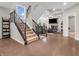 Inviting entryway featuring hardwood floors, a staircase with rod iron spindles, and view to the adjacent living room at 6044 Shallow Crk Ln, Indianapolis, IN 46237