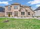Stunning brick home featuring a manicured lawn, elegant landscaping, and a welcoming front entrance at 6044 Shallow Crk Ln, Indianapolis, IN 46237