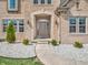 Charming front entrance with a pathway, decorative shrubbery, and stone accents at 6044 Shallow Crk Ln, Indianapolis, IN 46237