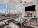 Living room featuring a stone fireplace, coffered ceiling, oversized windows, and a large leather sofa at 6044 Shallow Crk Ln, Indianapolis, IN 46237