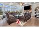 Living room with coffered ceiling, stone fireplace, a large TV, and oversized windows for natural light at 6044 Shallow Crk Ln, Indianapolis, IN 46237