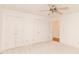 Bright bedroom featuring neutral carpet, ceiling fan, and double door closets at 6315 Hansbrough Way, Indianapolis, IN 46268