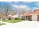 Attractive single-story home with a red roof, brick accents, driveway, and manicured lawn at 6315 Hansbrough Way, Indianapolis, IN 46268