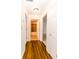 Hallway featuring wood-look floors provides access to a tiled bathroom and carpeted room at 6315 Hansbrough Way, Indianapolis, IN 46268