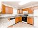 Well-lit kitchen features oak cabinets, granite countertops, modern appliances, and tile floors at 6315 Hansbrough Way, Indianapolis, IN 46268