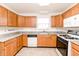 Well-lit kitchen with wood cabinets, granite countertops, and appliances included at 6315 Hansbrough Way, Indianapolis, IN 46268