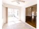 Open view from sunroom into a living room with a ceiling fan and wood flooring at 6315 Hansbrough Way, Indianapolis, IN 46268